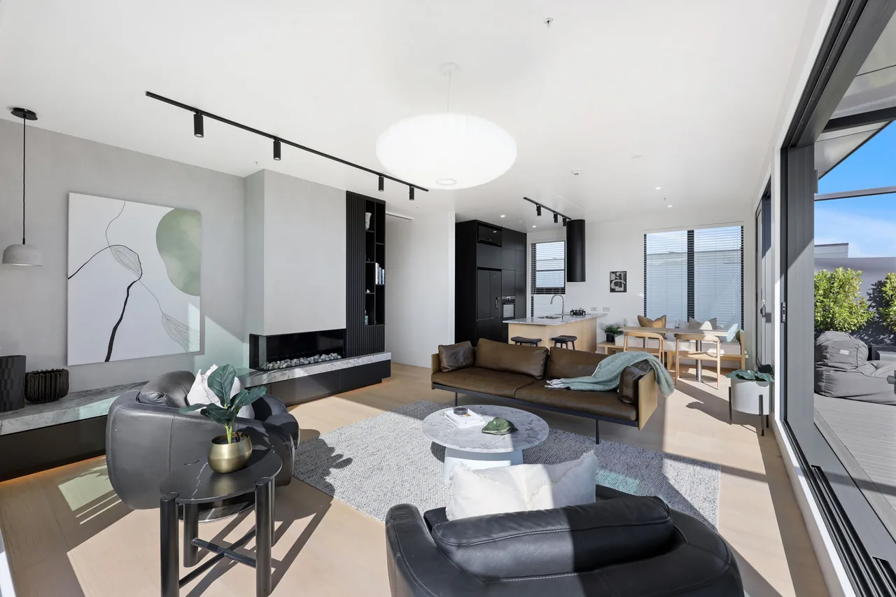 The living room of Penthouse 505 with the gas fire and full-height glazing