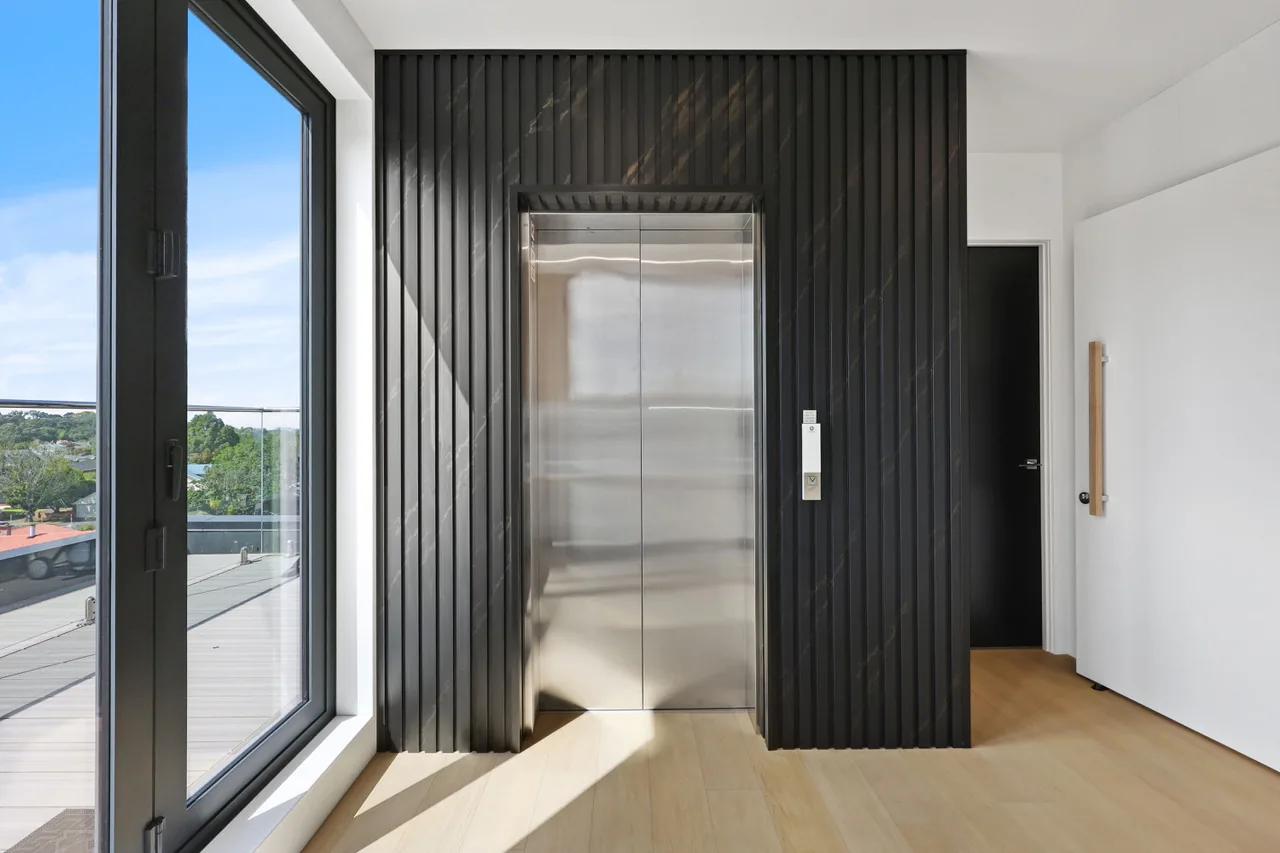 The private lift at Penthouse 505, framed in dark timber battens