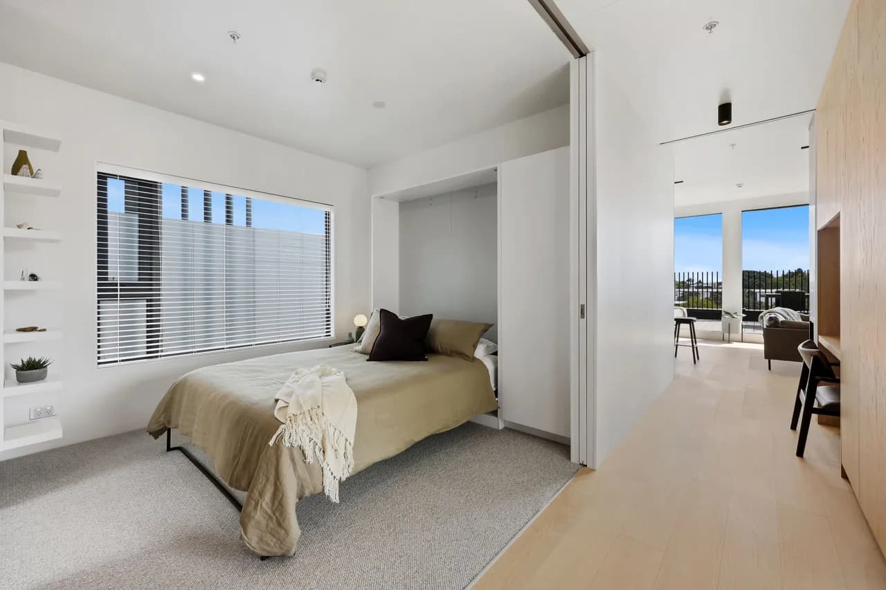 The second bedroom at Penthouse 505, murphy bed down, with oak joinery and built-in storage