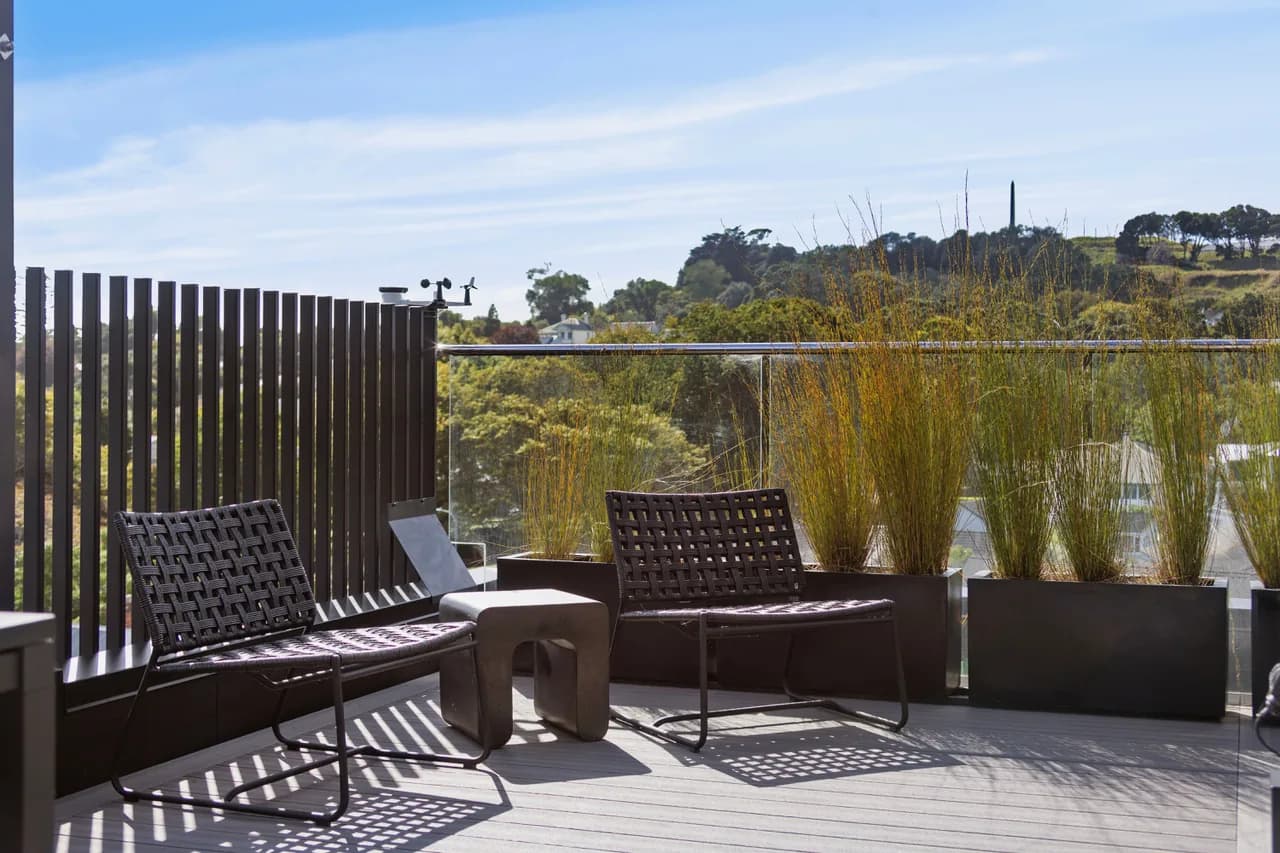 Seating on the terrace of Penthouse 505, with One Tree Hill on the horizon beyond the planting
