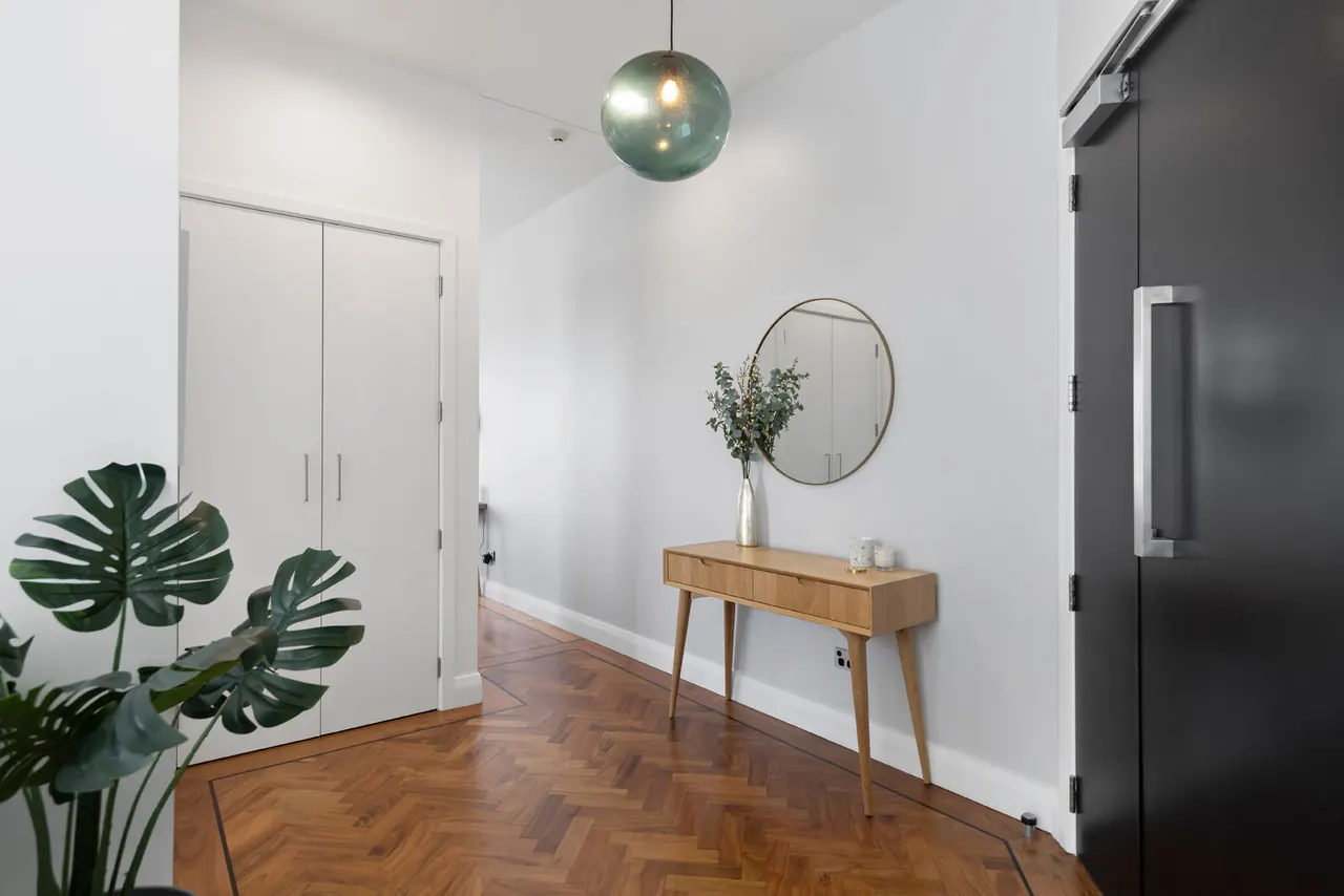 The entry hall of Penthouse 504, inside the front door, with walnut parquet and cupboards