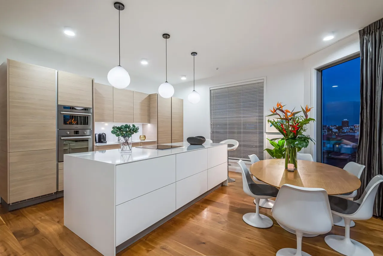 Poggenpohl kitchen with a white stone waterfall island and hand-blown pendant lights