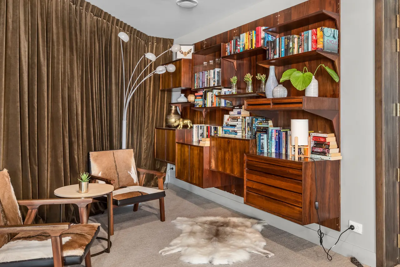 The residents' library, with walnut shelves and leather chairs
