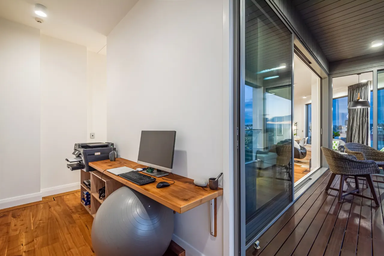 The private office with a walnut desk, opening onto the deck